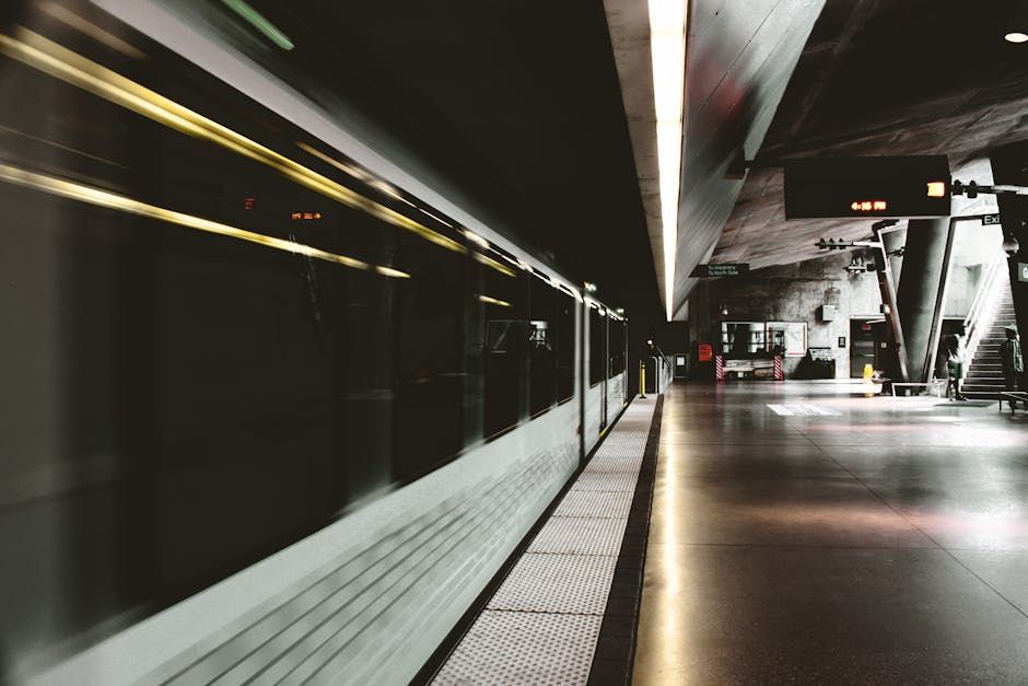 Subway station at night with a blurred train rushing by.